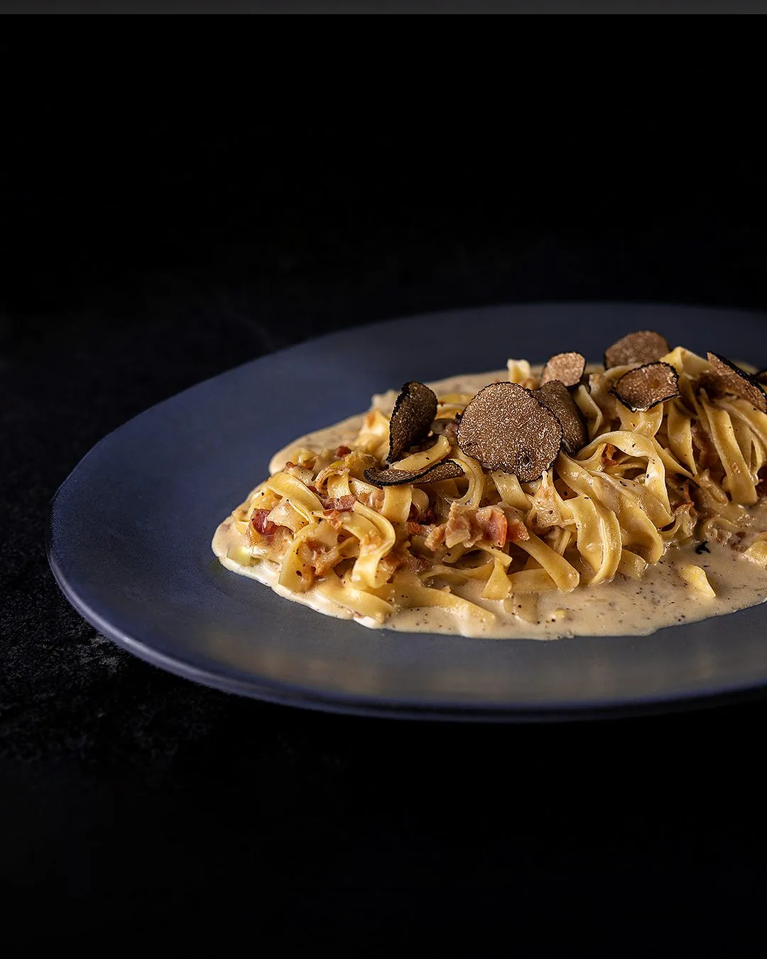 Pasta con trufa sobre fondo negro